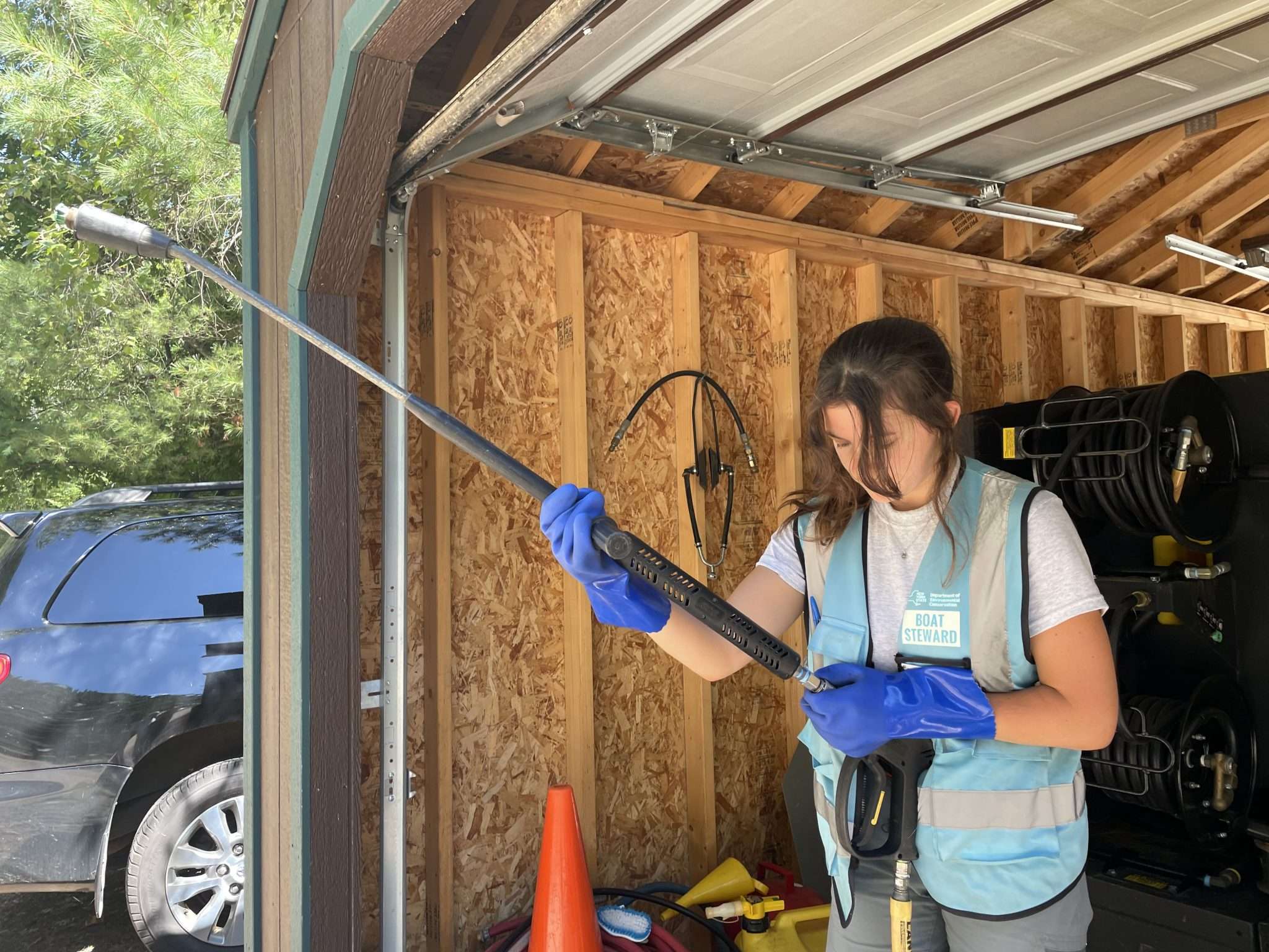 Boat steward Kelly Bonnville prepares the machine used to clean boats with hot water. Photo by Zachary Matson