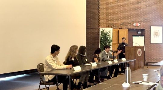 panelists sit at a table