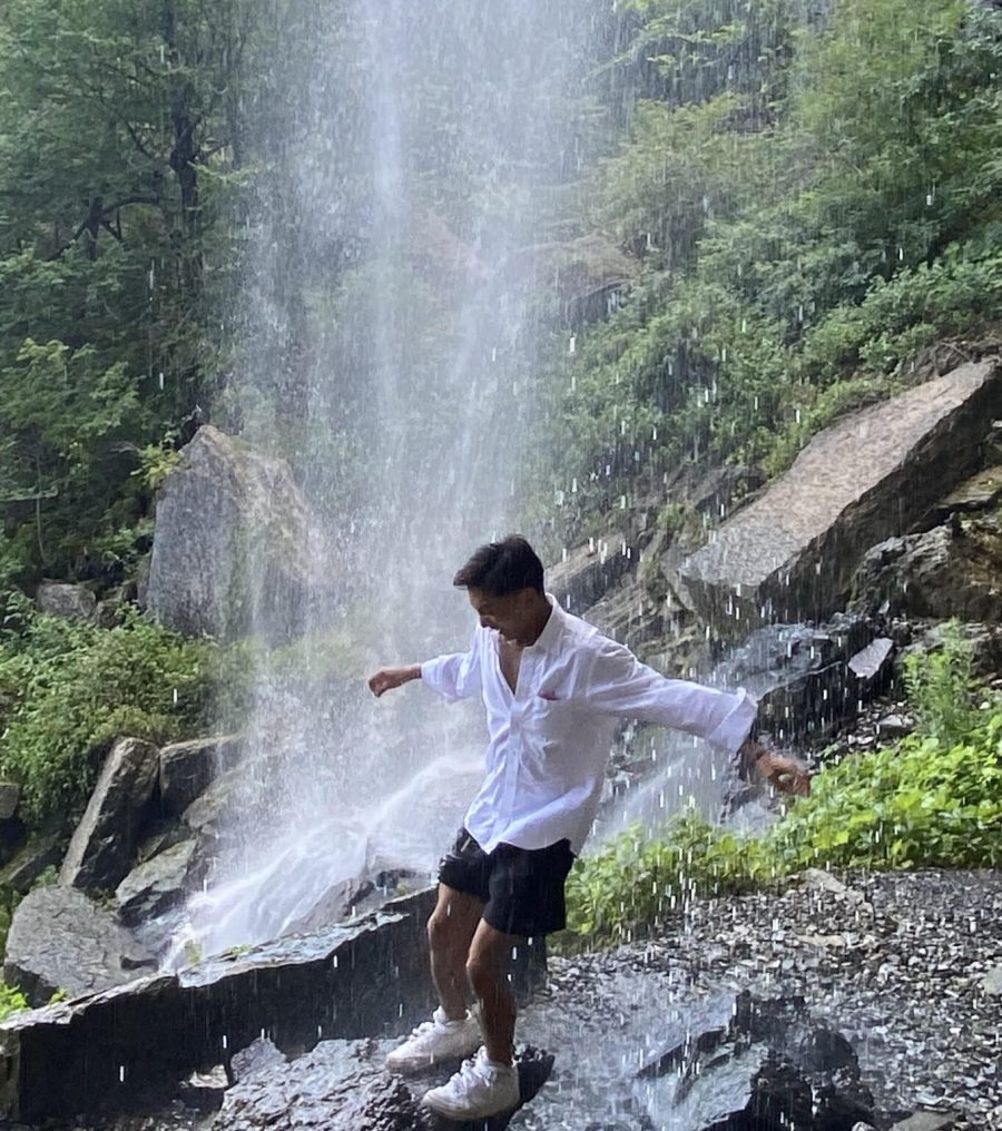 Man in water near waterfall