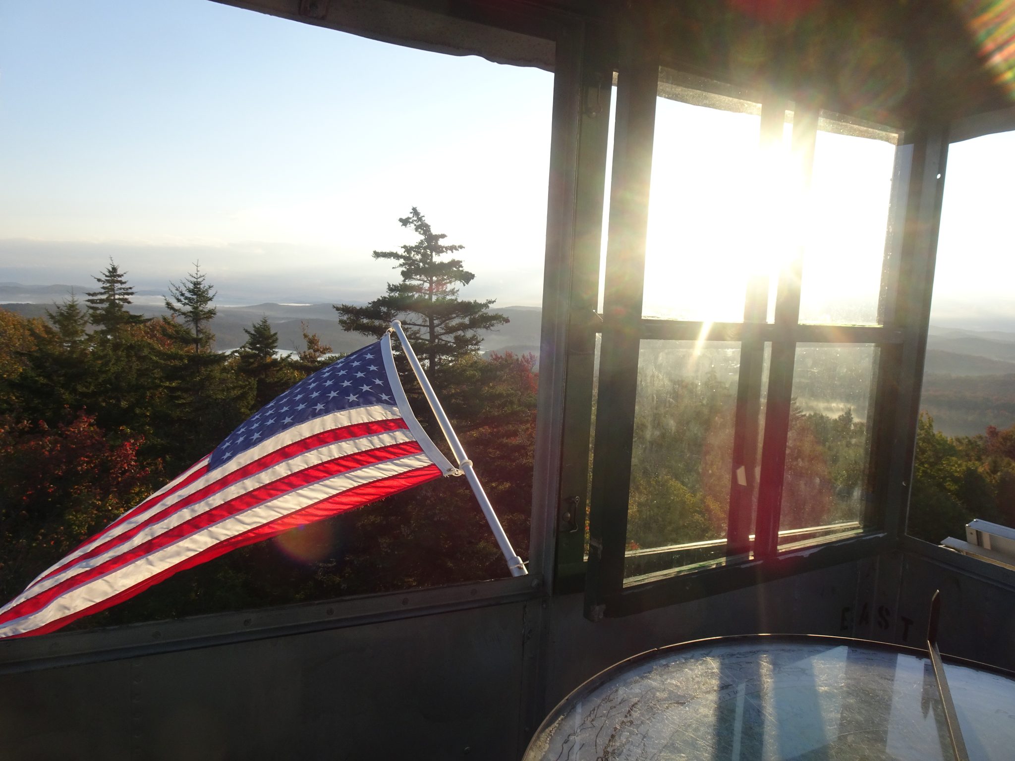 A flag waves outside a fire tower on Stillwater Mountain.