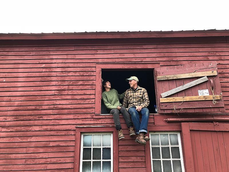 two people in a barn window