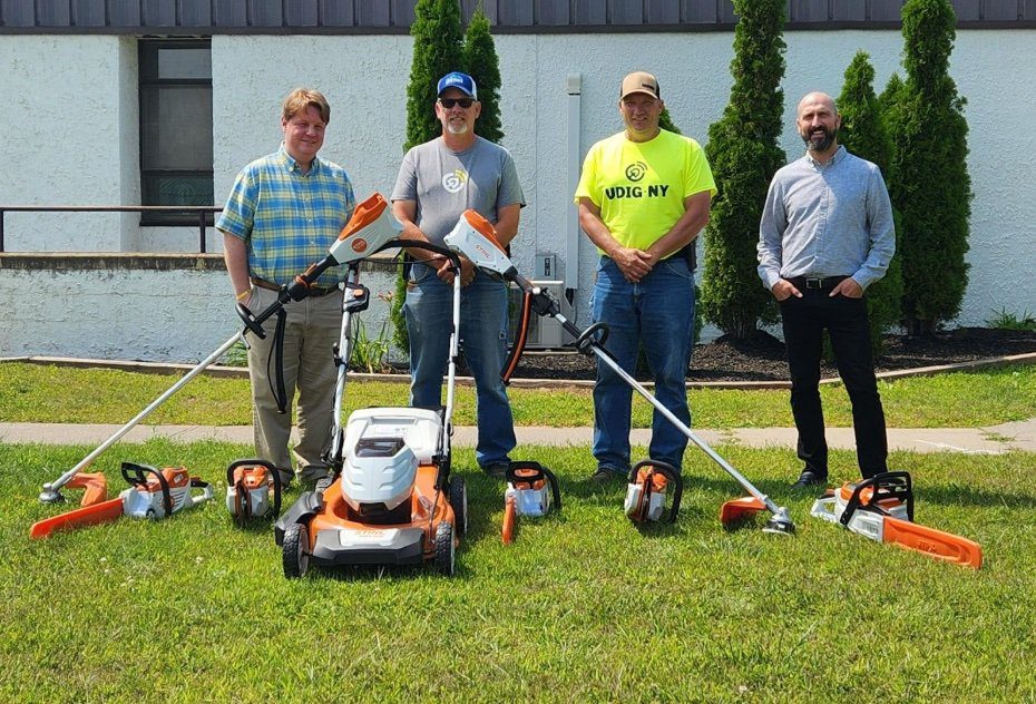 People stand with landscape equipment